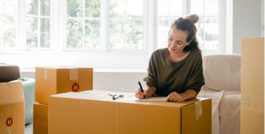 Girl Packing Boxes and Writing on them